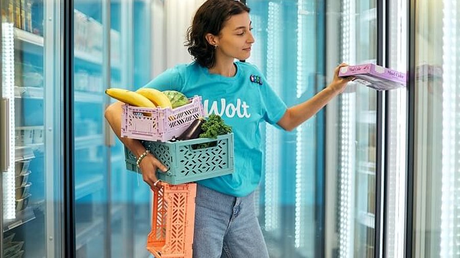 Frau mit Lebensmitteln im Wolt Market Supermarkt