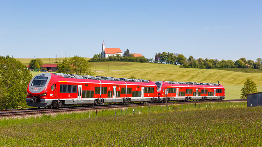 Regionalzug Nahverkehr Deutsche Bahn fährt durch Landschaft