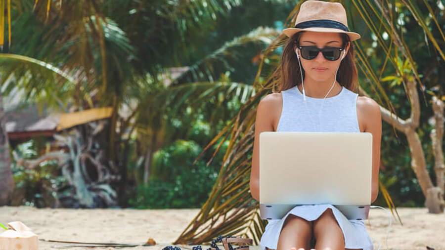 Frau am Strand mit Laptop