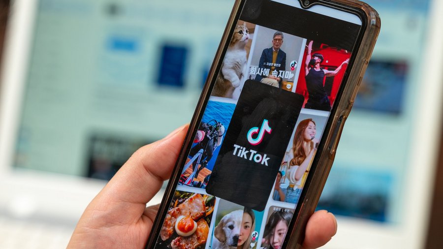 Person hält Smartphone mit TikTok-App