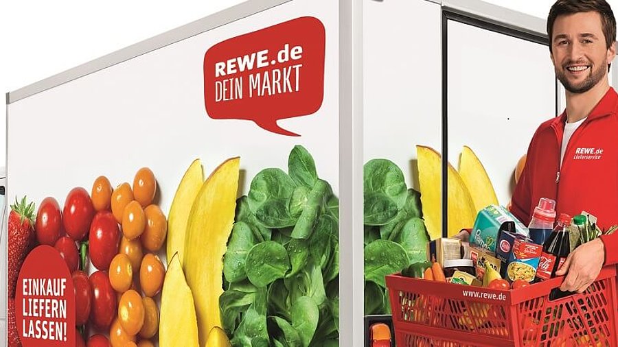 Mann vor Rewe-Lieferwagen