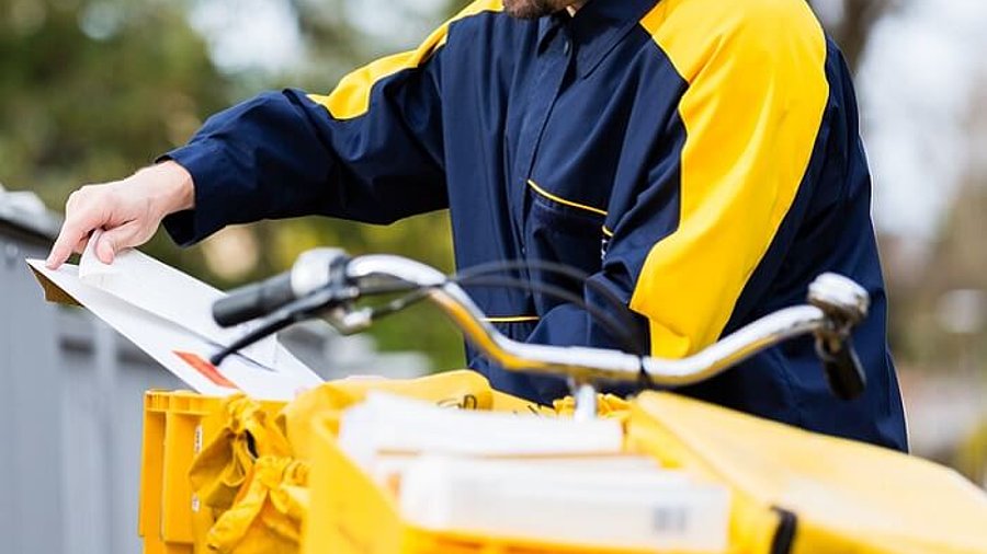 Postman delivering letters to mailbox of recipient