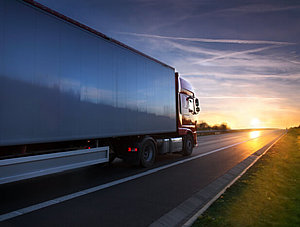 Lkw fährt auf Straße in den Sonnenuntergang