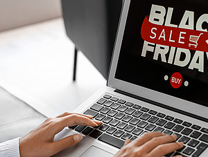 Frau mit Laptop beim Black Friday Sale