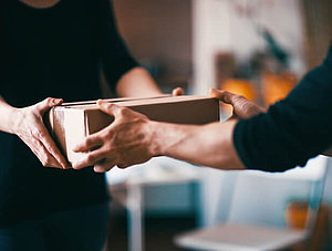 Übergabe Paket zwischen zwei Personen