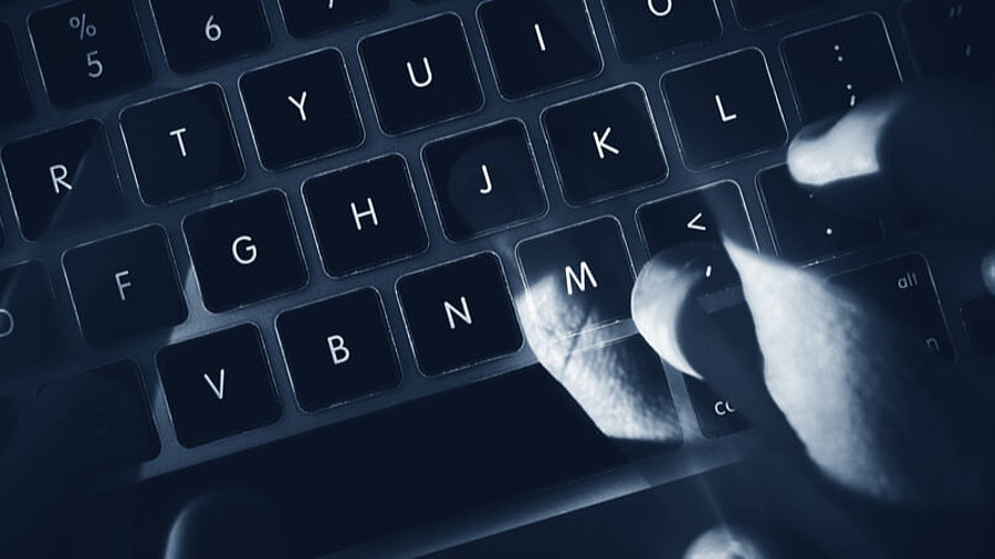 Cyberangriffe: Hacker auf einer dunklen Tastatur