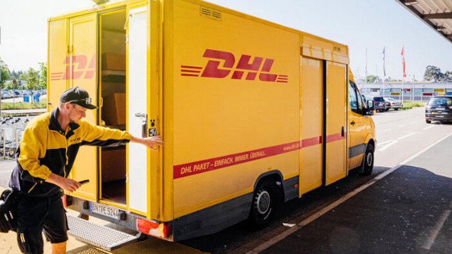 DHL-Zusteller mit Wagen