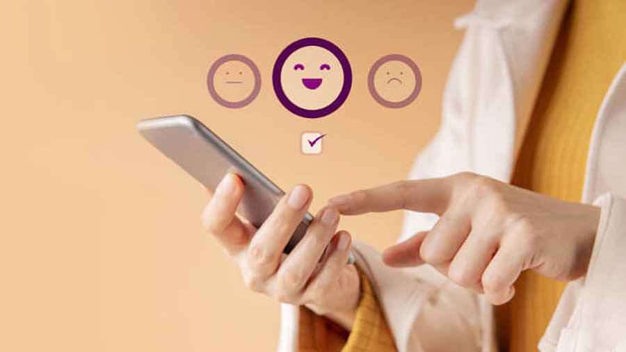 Person klickt Emojis auf Smartphone an für Feedback