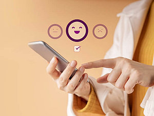 Person klickt Emojis auf Smartphone an für Feedback