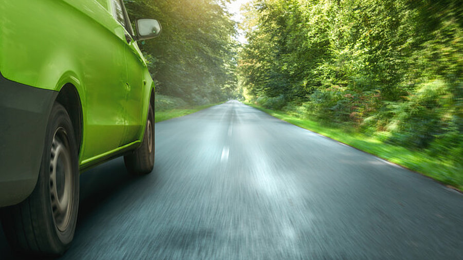 Grüner Lieferwagen, der durch den Wald fährt