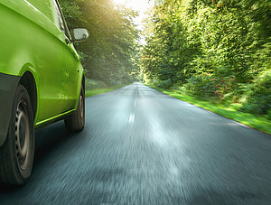 Grüner Lieferwagen, der durch den Wald fährt