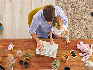 Familie sitzt am Tisch und arbeitet