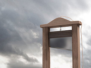 Guillotine vor grauem Himmel