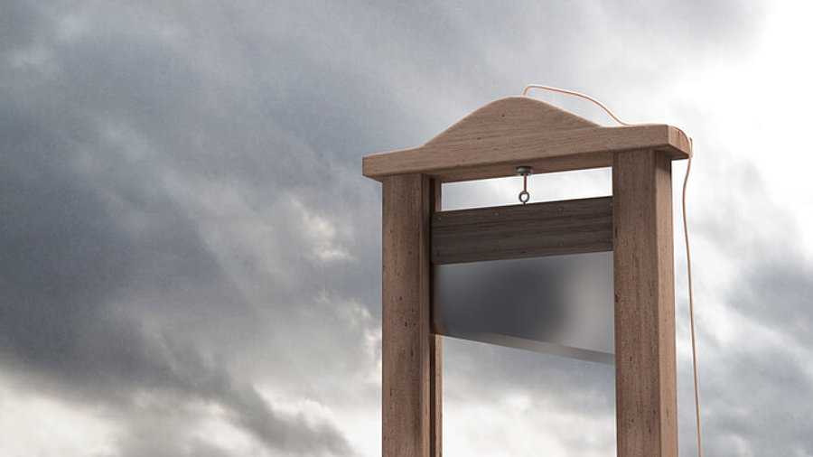 Guillotine vor grauem Himmel