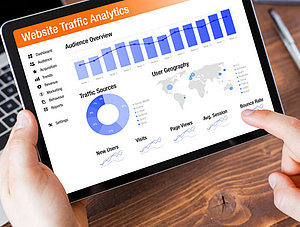 Mann, der die Daten der Website-Analyse auf dem Tablet ansieht