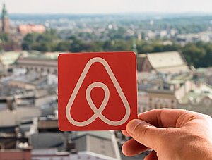 Airbnb Logo vor Stadt