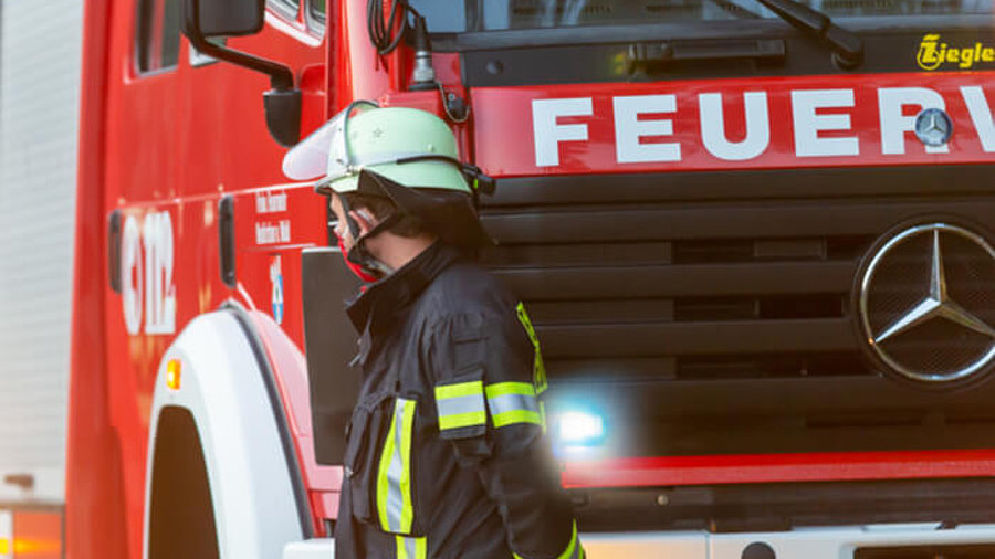 Feuerwehrmann vor einem Feuerwehrwagen