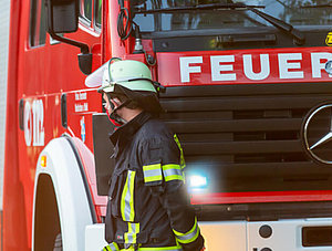 Feuerwehrmann vor einem Feuerwehrwagen