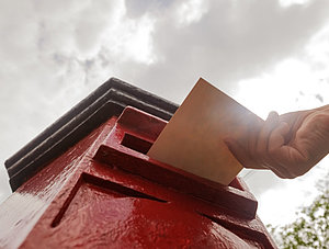 Brief wird in Briefkasten geworfen