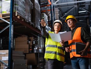 Zwei Personen besprechen sich in einem Logistiklager