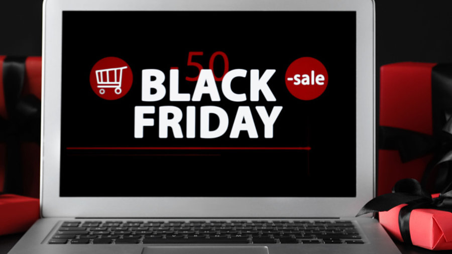 Laptop mit Black Friday Schriftzug umringt von Geschenkpaketen