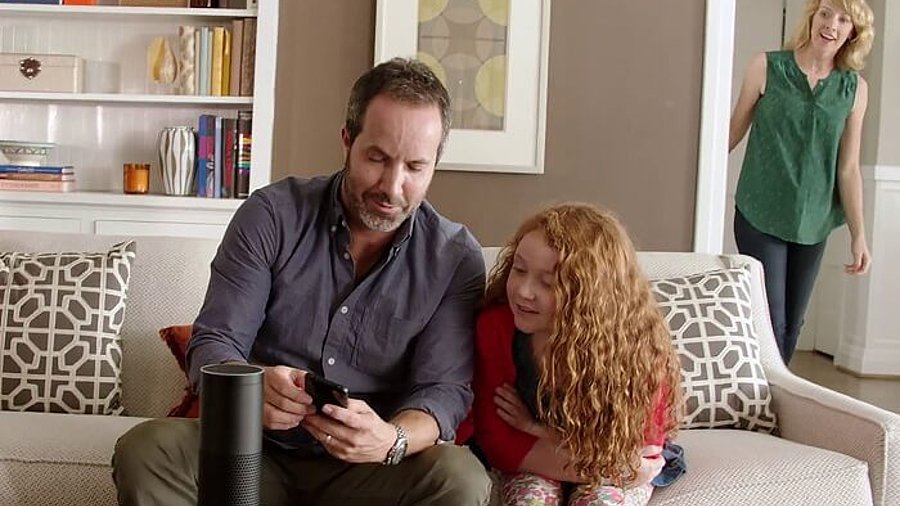 Amazon Echo steht auf Sofa Tisch, Familie im Hintergrund