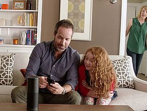 Amazon Echo steht auf Sofa Tisch, Familie im Hintergrund