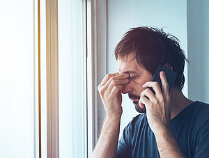 Mann am Telefon ist genervt