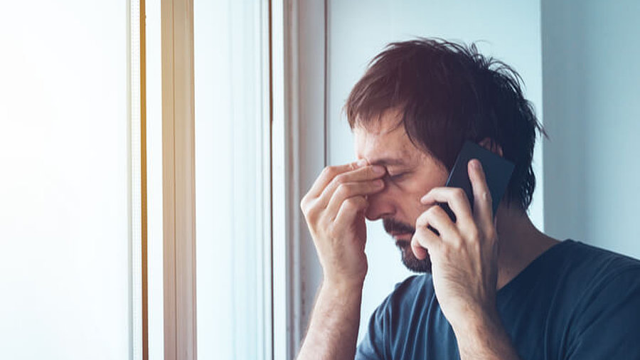 Mann am Telefon ist genervt