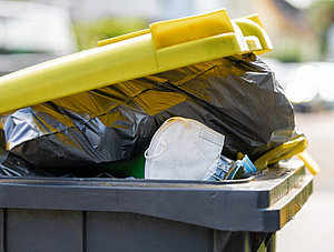 Gelbe Mülltonne mit Müll Verpackungen