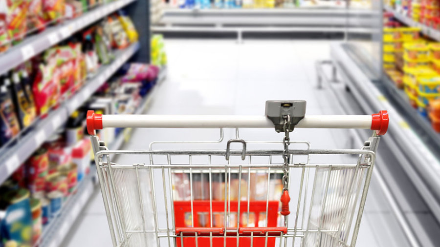 Einkaufswagen zwischen Supermarktregalen