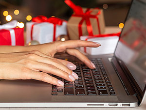 Person am Laptop Online-Shopping zu Weihnachten