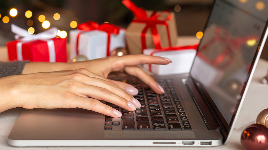 Person am Laptop Online-Shopping zu Weihnachten