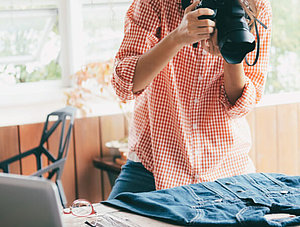 Frau mit Fotoapparat fotografiert Bluse 