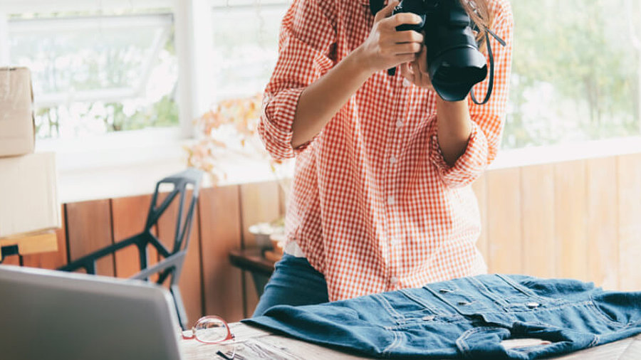 Frau mit Fotoapparat fotografiert Bluse 