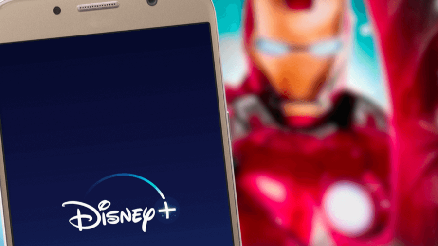 Disney+-App auf einem Smartphone. Streaming-Dienst auf TV dahinter.