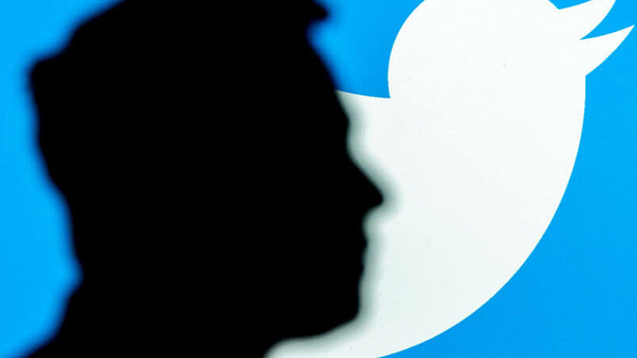 Elon Musk. Schwarze Silhouette vor Twitter-Logo