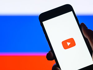 YouTube auf Smartphone vor Russland-Flagge