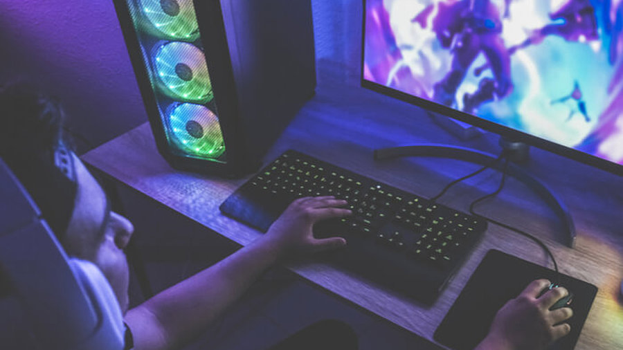 Gamer sitzt am PC und zockt Spiele