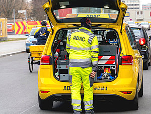 Mitarbeiter des ADAC vor einem Pannenservice-Fahrzeug