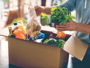 Essen in einem Karton: Mann mit Lebensmittel-Lieferung