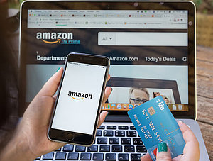 Smartphone, Kreditkarte und Laptop mit Amazon