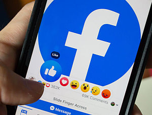 Person likt Beitrag auf Facebook auf Smartphone