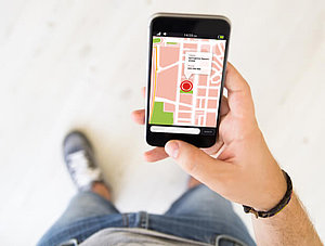 Mann hält Smartphone mit Karten-App