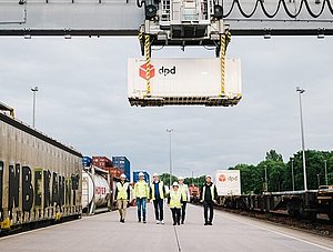 DPD Team  und Container neben Güterzug