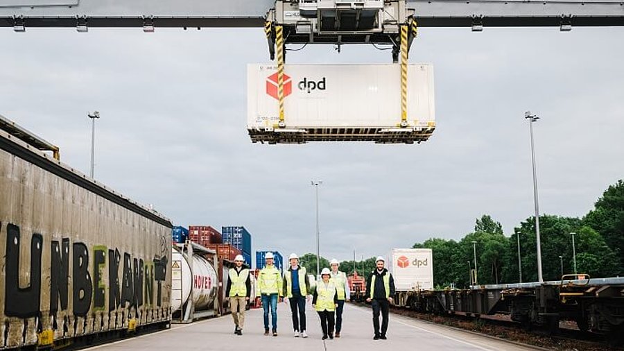 DPD Team  und Container neben Güterzug