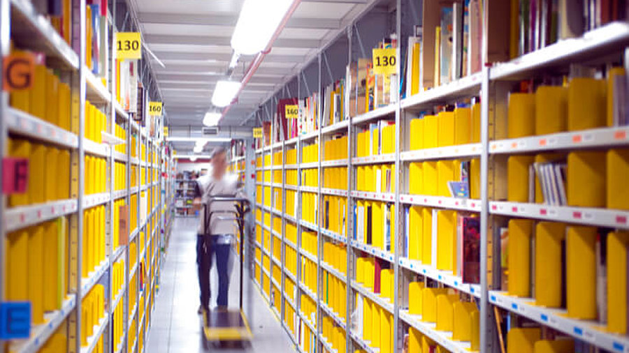 Pickerin im Logistikzentrum zwischen Regalen