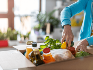 Frau nimmt Lebensmittel aus Paket