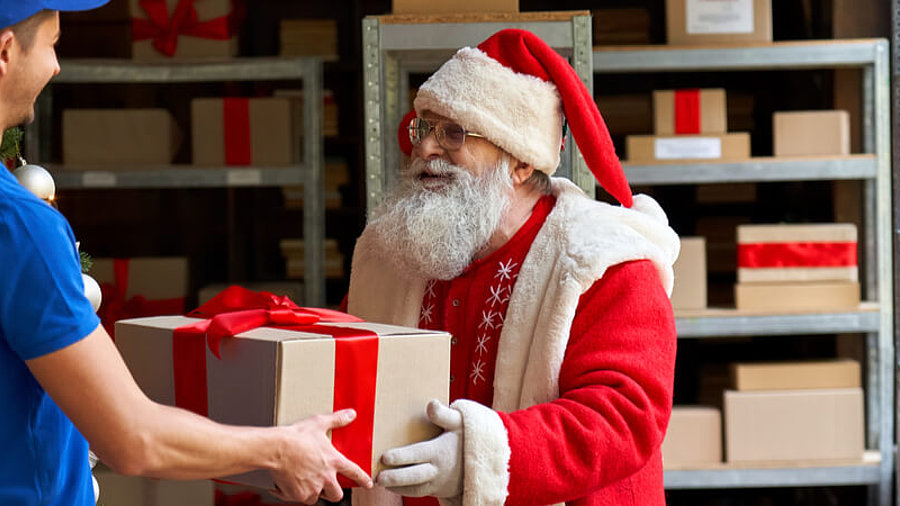 Weihnachtsmann &uuml;bergibt Paket