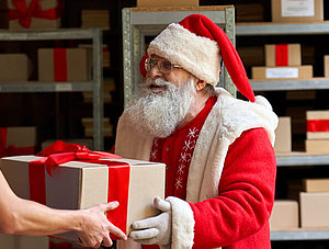 Weihnachtsmann &uuml;bergibt Paket